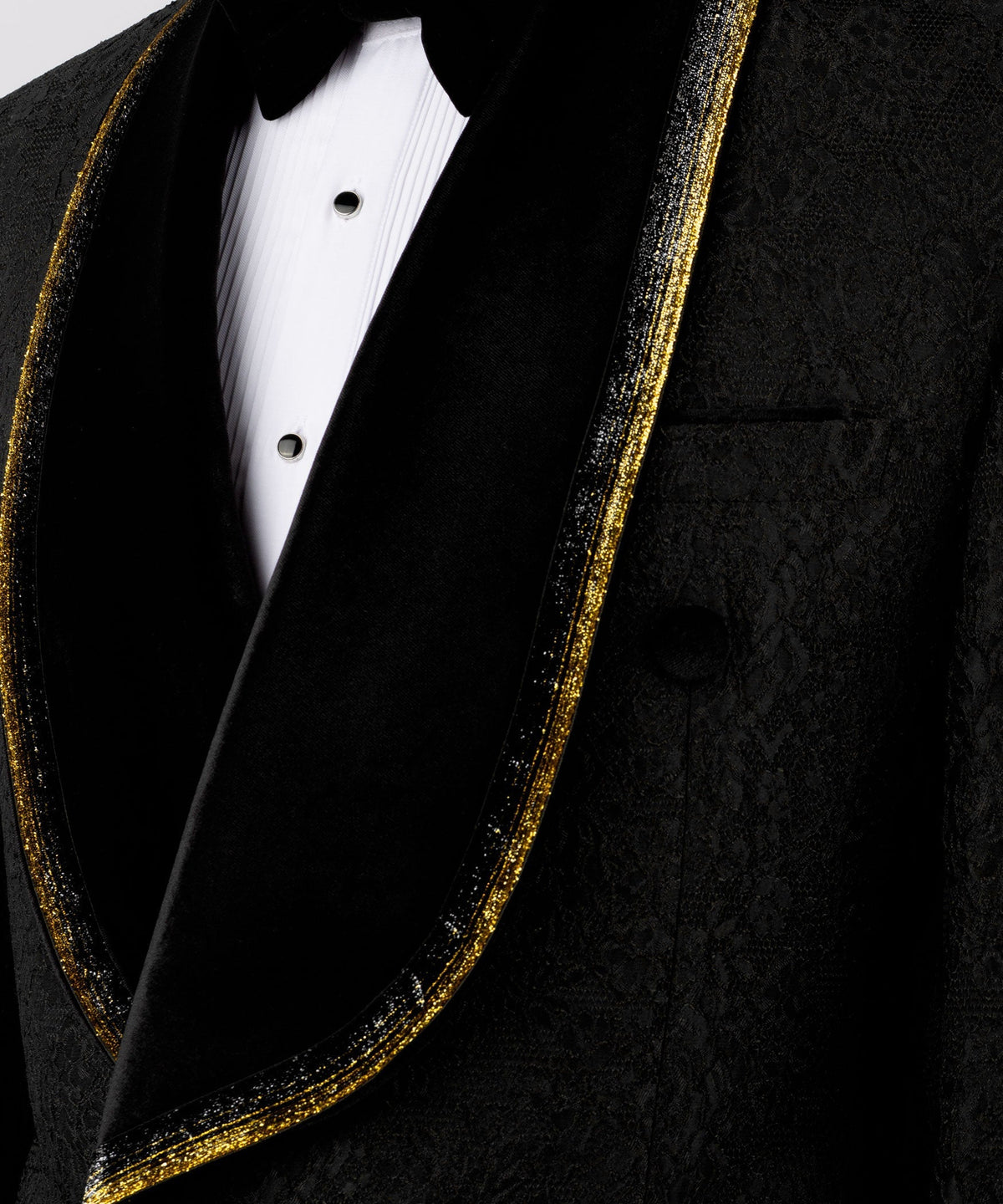 Close-up of black velvet lapels with gold embroidered trim and black satin vest